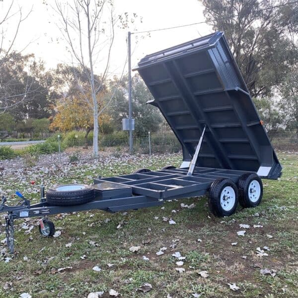 Hydraulic tipper trailer in parkland.