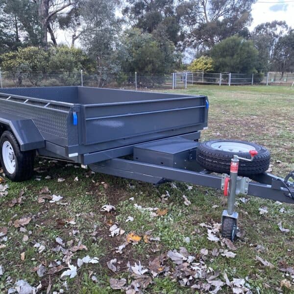 Dual axle box trailer parked on grass.