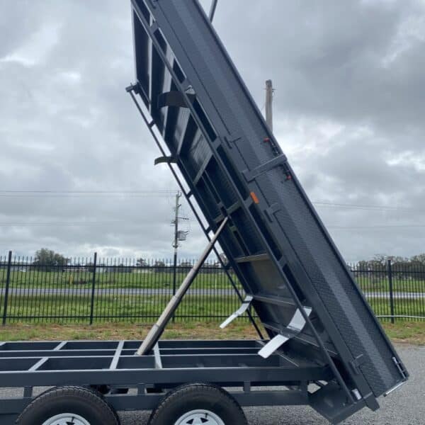 Tipper trailer with raised flatbed on cloudy day.